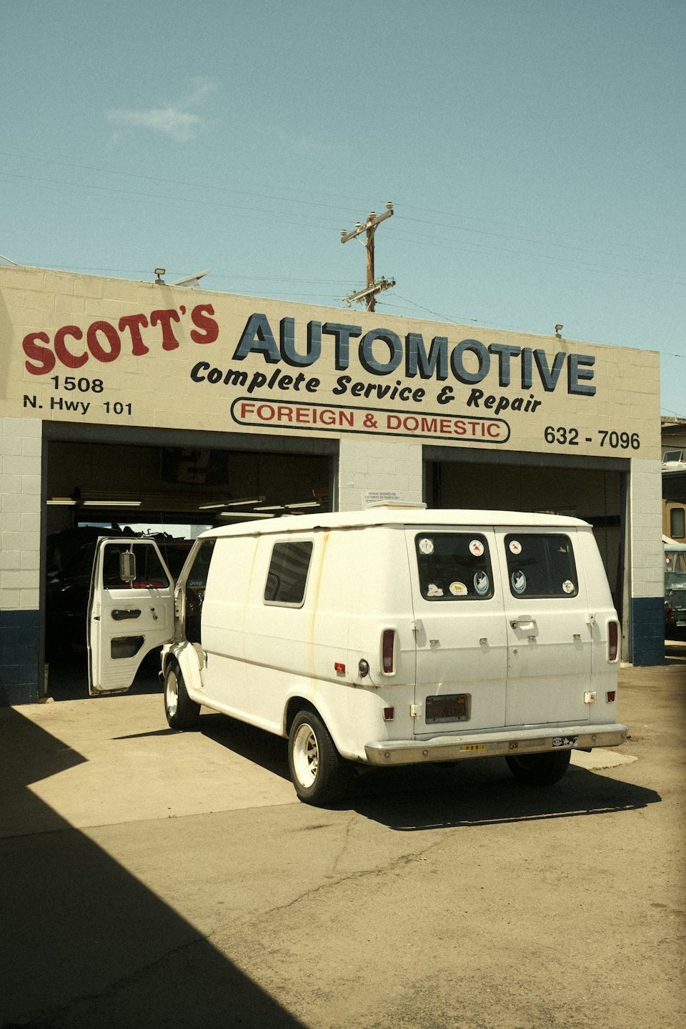 Vintage panel van parked outside Scott's Automotive repair shop.